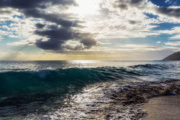 Evening view with sun shining throug clouds at Makua beach, Oahu, Hawaii