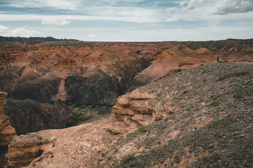 Charyn Grand Canyon with clouds and sun red orange stone Martian landscape