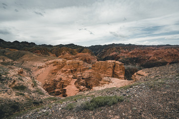 Charyn Grand Canyon with clouds and sun red orange stone Martian landscape