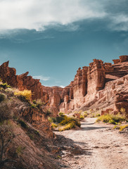 Charyn Grand Canyon with clouds and sun red orange stone Martian landscape