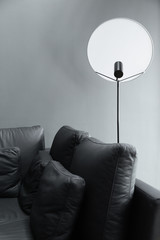 composition modern black and white floor lamp with black leather sofa in natural light