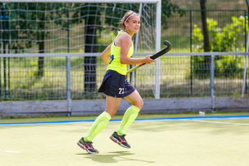 Obraz premium Young field hockey player girl with stick in the game