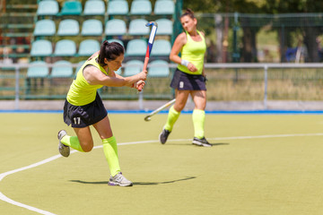 Fototapeta premium Young hockey player hit the ball in field hockey game