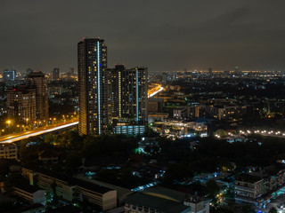 Fototapeta na wymiar Buildings and highway road in city at night