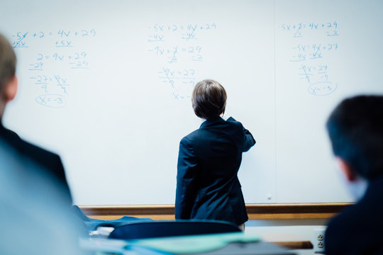 student works on math problems on whiteboard