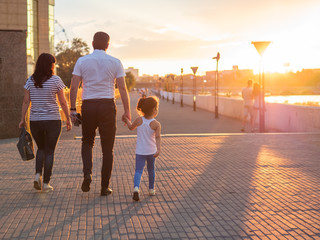 Fototapeta premium Happy family walks in the evening light