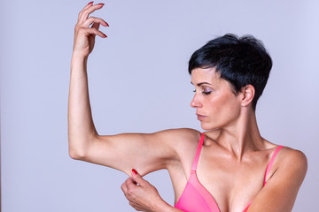 Calm woman stretching skin on bent arm