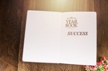 sucess education book on wooden table and backgroun din light vintage tone