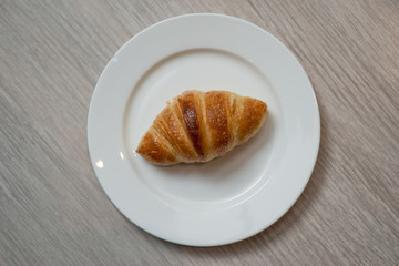 Plain croissant on white plate