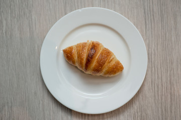 Plain croissant on white plate