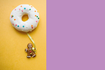 Gingerbread man holds a donut in his hand that looks like a balloon. Creative idea. Holiday...