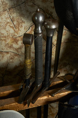 three historical swords stand in wooden rack for weapons