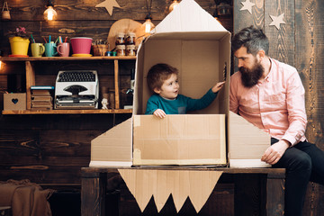 child as astronaut with toy rocket playing and dreaming of becoming a spacemen. Portrait of funny kid and father. Family friends games