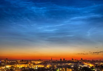 Foto op Canvas Noctilucent clouds over the city downtown at summer night © Vasily