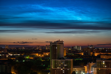 Noctilucent clouds over the city downtown at summer night