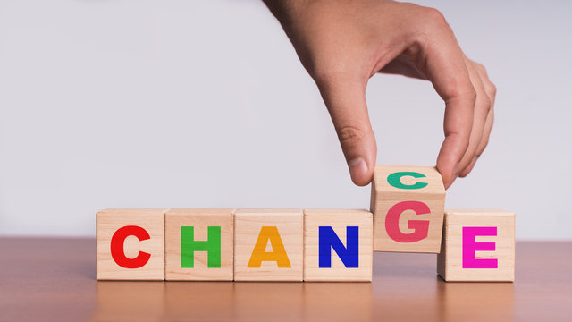 Hand hold flip wooden cube with word "change" to "chance"