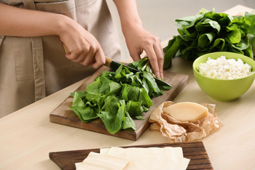 Woman cooking spinach lasagna in kitchen © Africa Studio