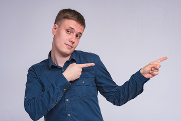 portrait of a young handsome man on a white background in a shirt showing on a product