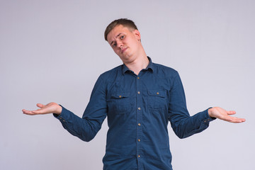 portrait of a young handsome man on a white background in a shirt showing different emotions of happiness and surprise.