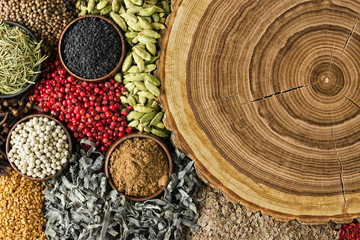 Various spices and herbs background. Condiments with empty wooden surface.
