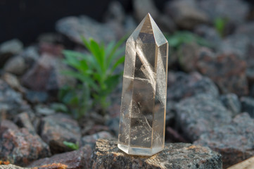 Large transparent mystical faceted crystal of white quartz on a stone background close-up. Wonderful mineral of the royal size for the designer