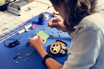 Caucasian technician installing a resistors to motherboard