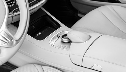 Media and navigation control buttons of a Modern car. Car interior details. White leather interior of the luxury modern car. Modern car interior. Car detailing. Black and white