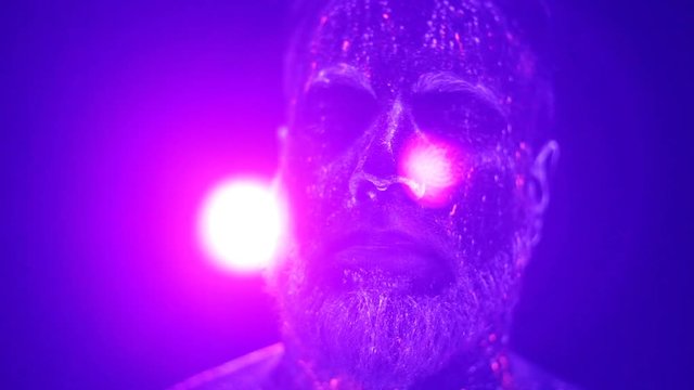 Concept. Portrait of a bearded man. The man is painted in ultraviolet powder