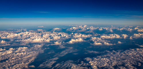 View from airplane window showing clouds and mountains in central europe.