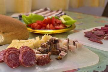 Serbian breakfast with sliced domestic sausage, bacon, ham and cheese.