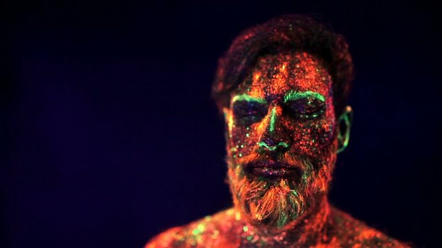 Portrait of a bearded man in ultraviolet light in smoke