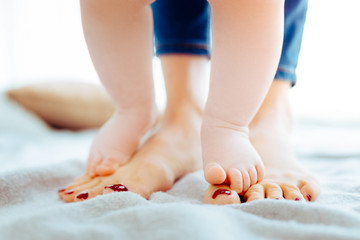 Step by step. Little feet being bare while touching mother