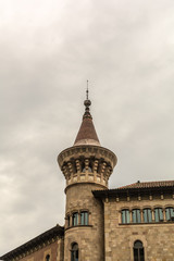 Fototapeta na wymiar One of two towers of Municipal Conservatory of Barcelona with pointed top reminiscent of the 15th century castles. The brick and stone building was constructed in the years 1916-1927.