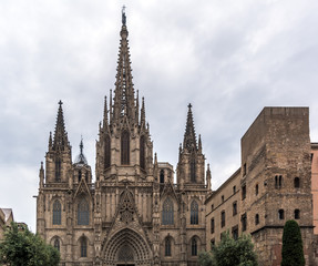 Neo-gothic facade of Barcelona Cathedral in the Gothic Quarter. Facade is decorated with statues, pinnacles, arches. The roof is notable for its gargoyles, featuring a wide range of animals.