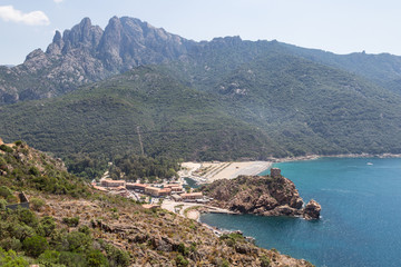 The resort town of Porto with its medieval fortification tower on a cliff by the mediterranean sea in Corsica, France