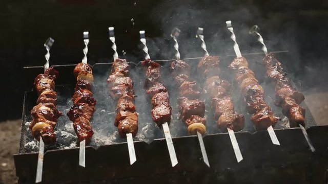 Fresh meat on a steel skewer in a smoke at brazier