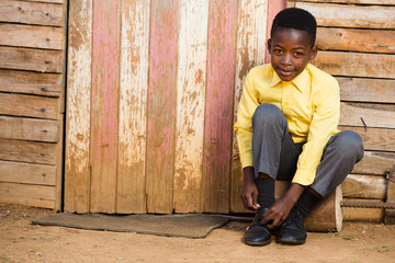 Cute black boy tieing his shoes