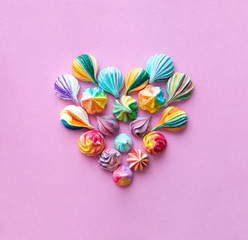 Colorful meringue cakes make a heart shape. The style of minimalism.