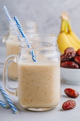 Banana and date fruit smoothie or milkshake in glass mason jar