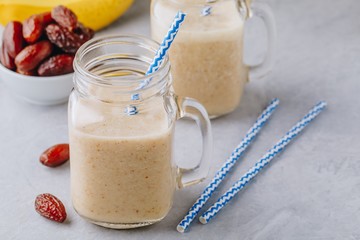 Banana and date fruit smoothie or milkshake in glass mason jar