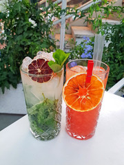 Set of alcohol cocktails in a bar. Green MOJITO cocktail and CAMPARI orange.