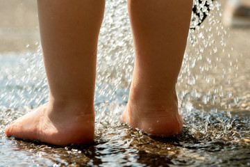 Kleinkind,Blick auf Füße, planschend in spritzendem Wasser