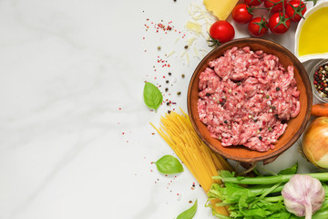 raw ingredients for cooking pasta bolognese over white marble table. cooking food concept. top view