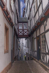 narrow paved cobblestone street steeply going down in the old part of the German city of Marburg