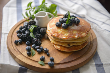Pancakes with blackberries, blueberries and mint on a chalkboard