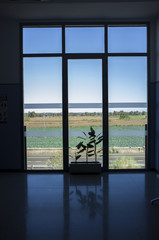 Large window from floor to ceiling to green farmland