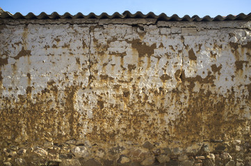 Old weathered mudwall with stone foundation