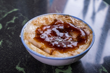 Taiwan's distinctive famous snacks: Savory rice pudding (Wa gui) in a white bowl on stone table, Taiwan Delicacies, Taiwan Street Food