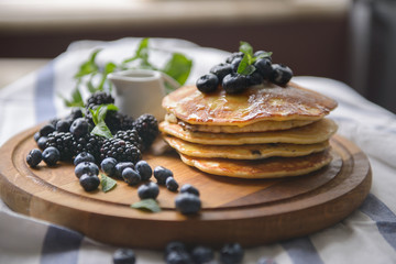 Pancakes with blackberries, blueberries and mint on the board