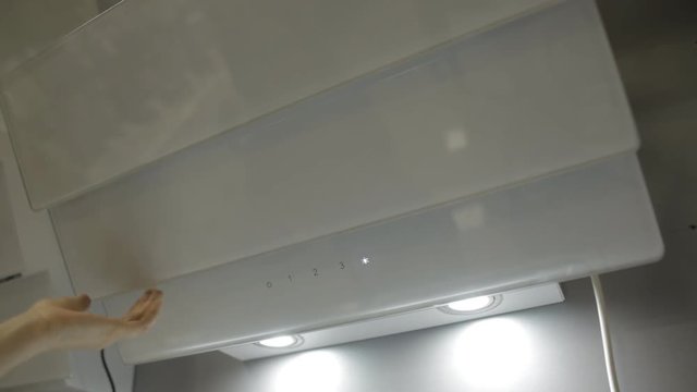 The girl presses the buttons on a modern stylish white hood, close-up, design